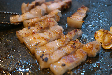 Grilling pork belly on an iron plate