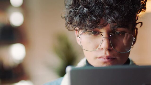 Coffee, cafe and student on a digital tablet, relax and reading online report at a restaurant. Face, study and man drinking coffee while thinking and planning online project or thesis at coffee shop