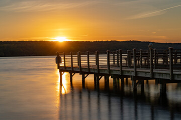 Sunset photo of the Myers Point pier at Myers Park in Lansing NY, Tompkins County. The dock, pier, is situated on the shore eastern shore of Cayuga Lake, near Ithaca New York.
