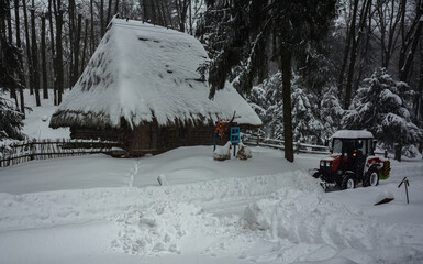 Snow removal tractor cleans alley in park.