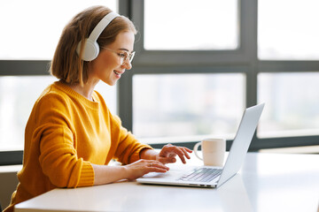 Happy young female having video call while working remotely or studying online on laptop from home