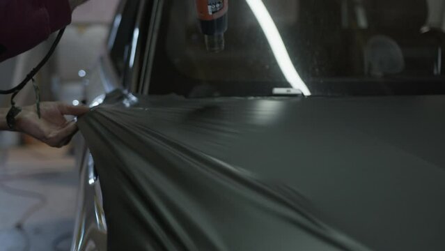 Vinyl Wrap Installation. Warming up vinyl with a heat gun.