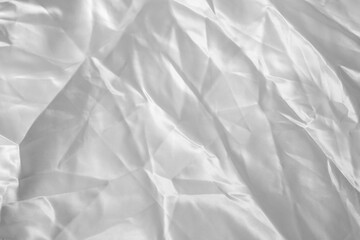 Fototapeta premium White crumpled satin fabric, abstract background close up