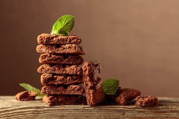 Brownie with mint on a wooden table.