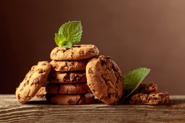 Chocolate cookies with mint on an old wooden table.