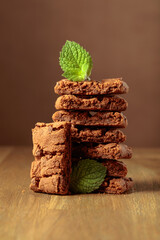 Brownie with mint on a wooden table.