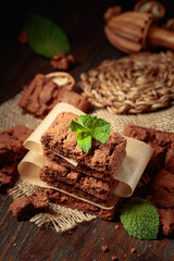 Fresh brownie with mint on a wooden table.