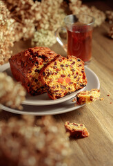  Fruit cake and tea on a wooden table with dried flowers.