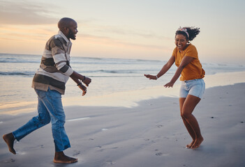 Love, freedom and couple at a beach at sunset, laughing and having fun on summer vacation in...