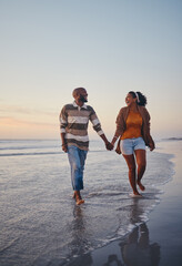 Travel, beach and couple walking in the sea, laughing and bonding on an ocean trip. Freedom, love and romance with black woman and man enjoy conversation and funny joke while holding hands in water - obrazy, fototapety, plakaty