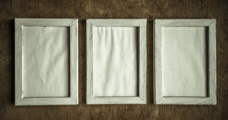 Fototapeta premium three vertical frames on a wooden wall in the style of shabby chic. Vintage frames with an empty middle