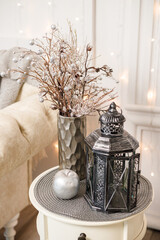 Decorative antique silver retro lamp on a white small table in the living room Interior decor in the house