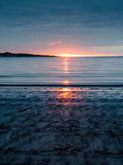 Stunning sun rise scene by the ocean. Dark blue and warm orange color. West of Ireland. Nature landscape scene. Calm and relaxing mood.