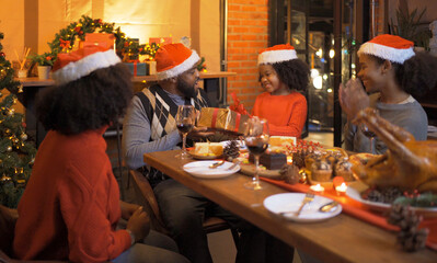 A group of African American black family, women girl have a celebration dinner in party on Merry Christmas Eve Xmas on holiday at home or house. People lifestyle. Happy New Year
