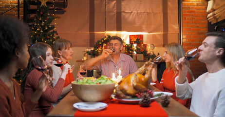 A group of multi ethnic. Portrait of Caucasian and African American black family, woman have a celebration dinner in party on Merry Christmas Eve Xmas on holiday at home or house. People lifestyle.