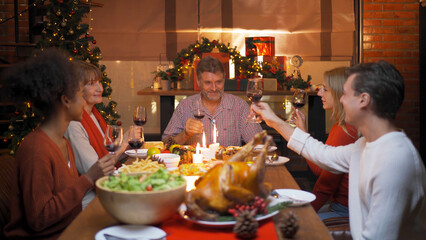 A group of multi ethnic. Portrait of Caucasian and African American black family, woman have a celebration dinner in party on Merry Christmas Eve Xmas on holiday at home or house. People lifestyle.