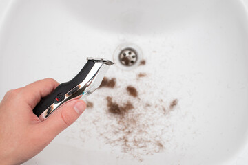 Man holding electric beard trimmer after shave beard with trimmer hair cut