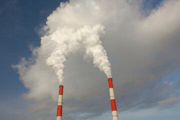 Smoking chimneys оf a thermal power plant in winter. Air pollution by harmful emissions, global warming.