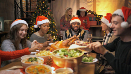 A group of multi ethnic.Portrait of Caucasian and African American black family have a celebration dinner in party with wine, champagne on Merry Christmas Eve Xmas on holiday at home. People lifestyle