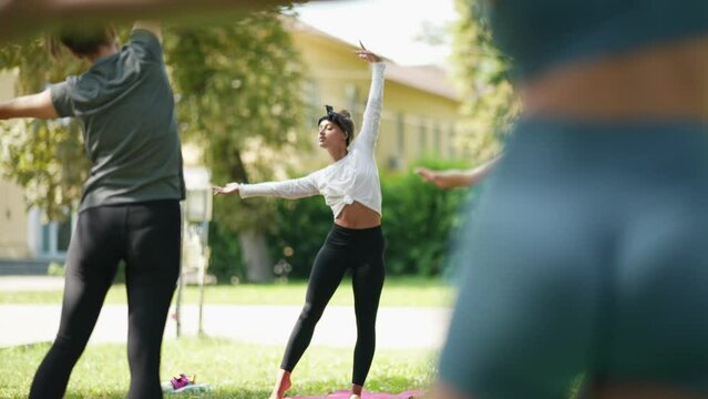 Group of young sporty woman practicing yoga lesson with instructor