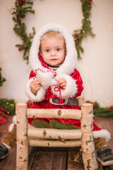 
Little cute boy dressed as Santa Claus in a room decorated for Christmas. Christmas and children