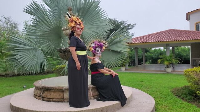 Women with catrina makeup posing for photos. Traditional Day of the Dead make up.