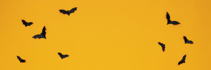 Concept of Halloween, paper bats on yellow background