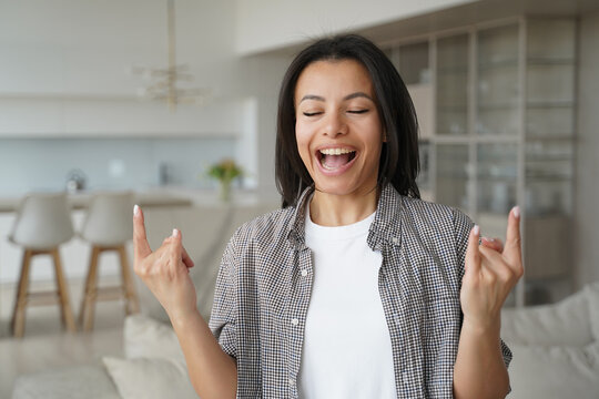 Excited Cool Young Woman Shows Hard Rock Hand Gesture, Screaming Singing At Home. Success, Happiness