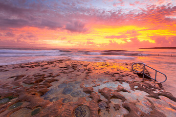 Ocean and rock pool overflow with amazing sunrise sky