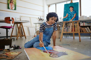 Painter, woman artist and creative on floor painting canvas in studio, workshop and gallery. Girl,...