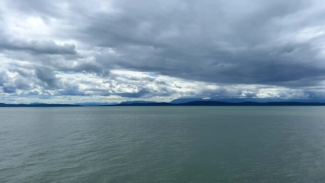 unrealistically white-gray silver Clouds on a bright blue sky a little Turquoise colorless water of the Pacific Ocean divide picture into two parts background for any title text or advertising travel