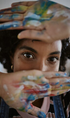 Hands, eyes and paint with a woman art student closeup with color painting on her palm for artistic...