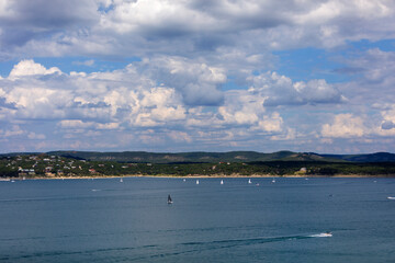 Sailboats and motorboats on the clear blue water