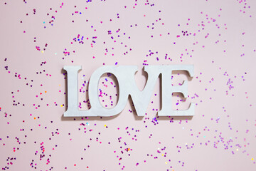 A letter Love over the red glitter background. 