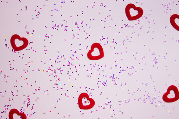 Red hearts over the pink glitter and pink background. 