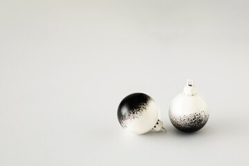 Minimal Christmas composition. Black and white baubles on white background. Christmas, winter, new year concept. Front view, copy space.