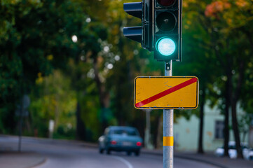 traffic semaphore with green light on defocused background of autumn city, closeup