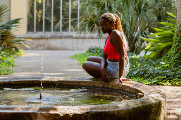 Top view of a woman sitting by the fountain in the park 