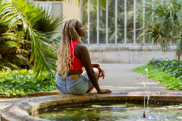 Top view of a woman sitting by the fountain in the park 