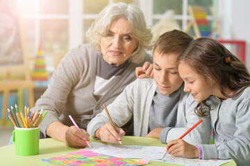 Portrait of grandmother with kids drawing at home