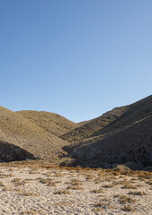 Montañas que se entrecruzan formando un camino a la arena.