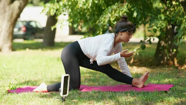 Athletic young woman in doing fitness exercise in the park