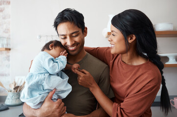 Love, baby and happy parents bonding and caring for their infant child in their comfy home....