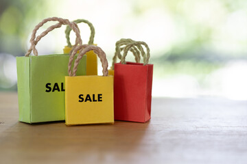 Tiny colored shopping bags with SALE text, annual sale, shopping season concept and promotion for sale in the year