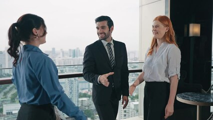 Businessmen and women shake hands after discussing and agreeing to work together at office building 