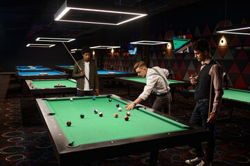 Friends enjoying billiard game at pool hall