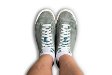 Top view of legs wearing used sneakers isolated on transparent background