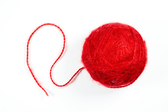 A ball of red woolen threads on a white background