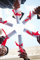 Graduation, diploma and hands with a student group outside in a huddle or circle from below. Graduate, success and university with friends holding a degree after completing college education