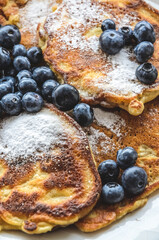 Delicious homemade pancakes with blueberries and powdered sugar, flat lay view from directly above